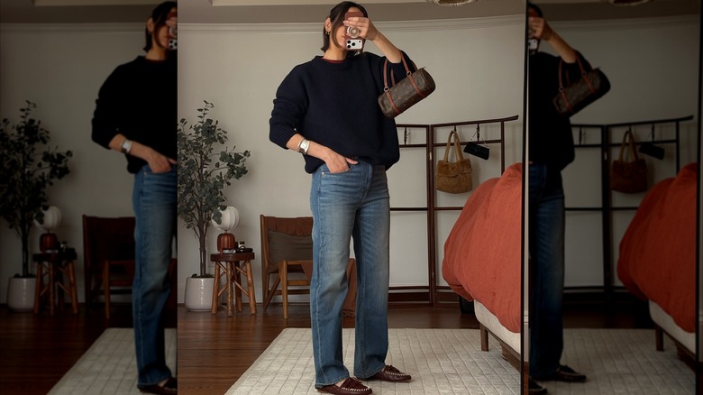 L'influenceuse de style Natalie Helen prend un selfie dans un miroir pour montrer son OOTD composé de mocassins marron, d'un jean droit et d'un pull surdimensionné.