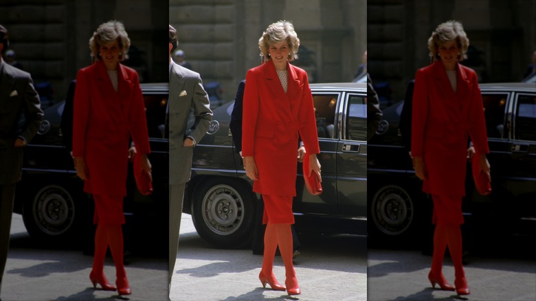La princesse Diana porte un costume rouge monochrome et des talons.