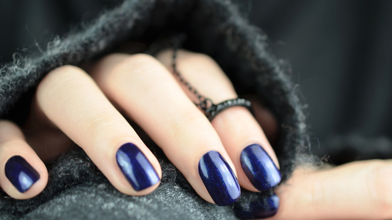 Une femme présentant une manucure bleu marine