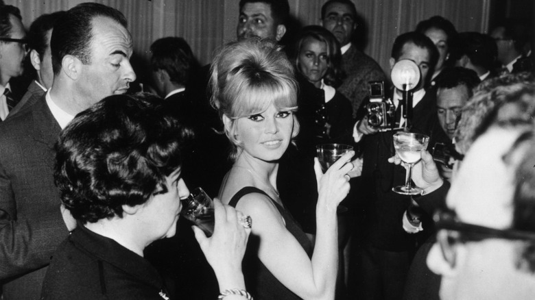Brigitte Bardot sourit avec une coiffure blonde en ruche.