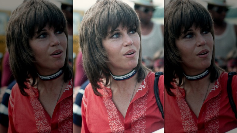 Jane Fonda pose avec une louve brune coupée avec une épaisse frange et d'épaisses brûlures latérales.