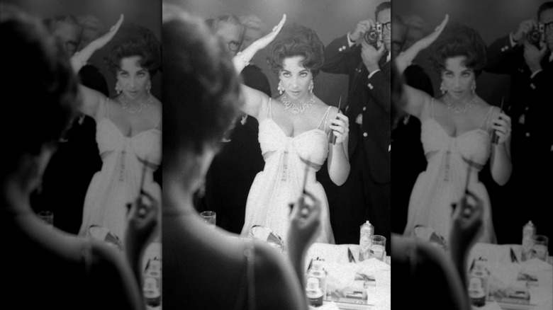 Elizabeth Taylor ajustant ses cheveux devant un miroir en 1959
