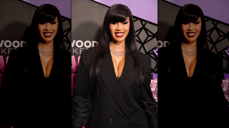 Cardi B porte un blazer noir et ses cheveux longs avec une frange sur le côté