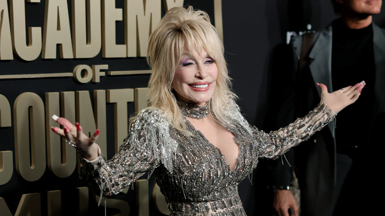 Dolly Parton tend les bras sur le tapis rouge