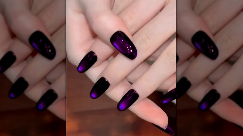 Un gros plan d’ongles œil de chat violets sur Instagram