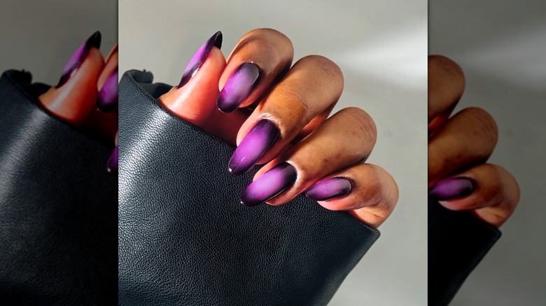 Une femme aux ongles violets portant un manteau en cuir sur Instagram