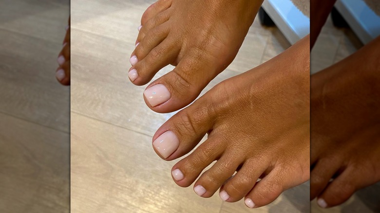 Une femme avec une pédicure rose pâle sur Instagram
