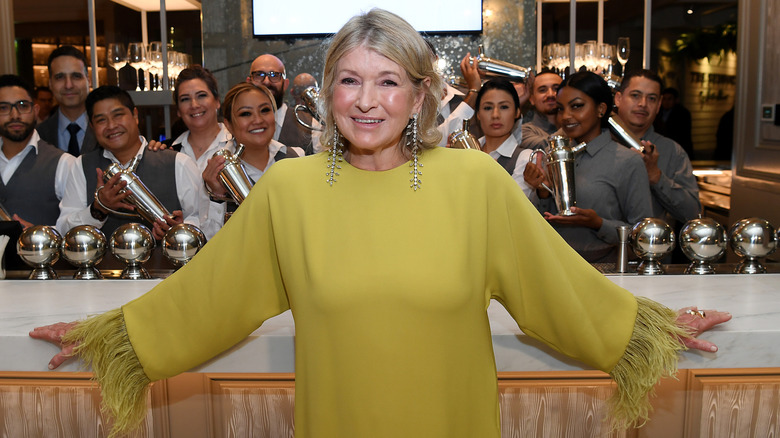 Martha Stewart en vert citron posant avec plusieurs serveurs